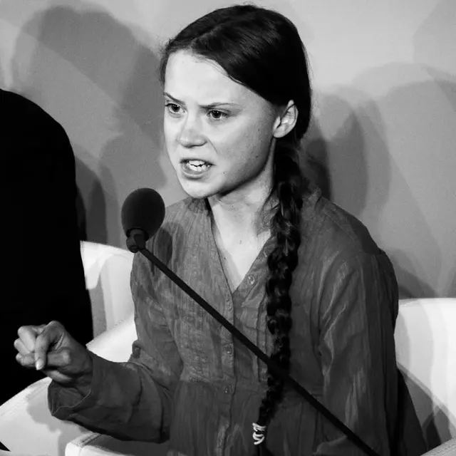 Greta Thunberg hablando ante un micrófono